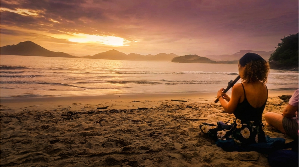Mujer practicando Meditación Melódica en la playa